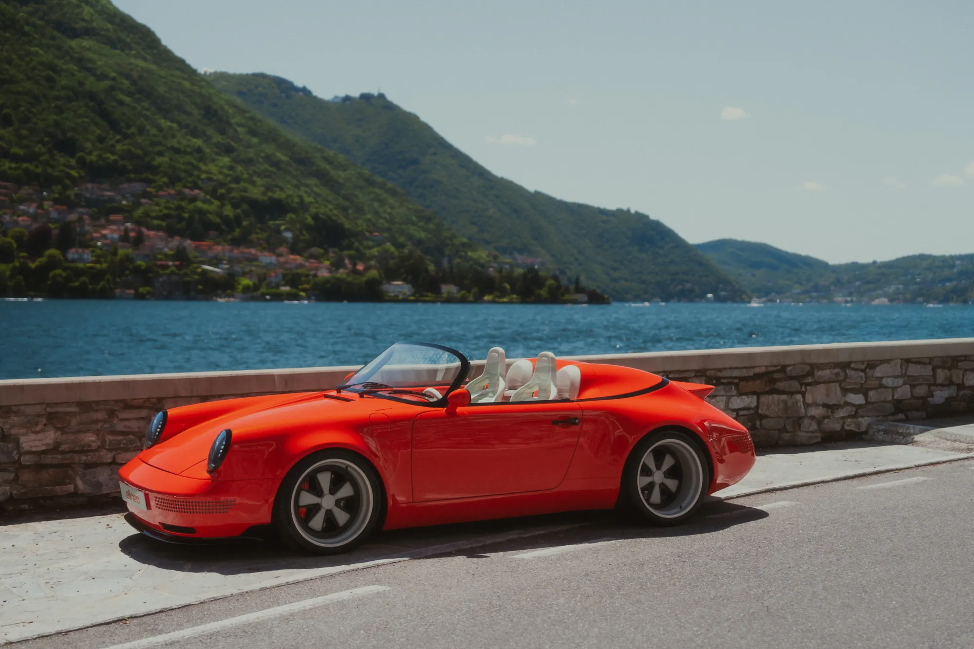 The Funkster parked along the lake wall, the water and mountains of Lake Como behind