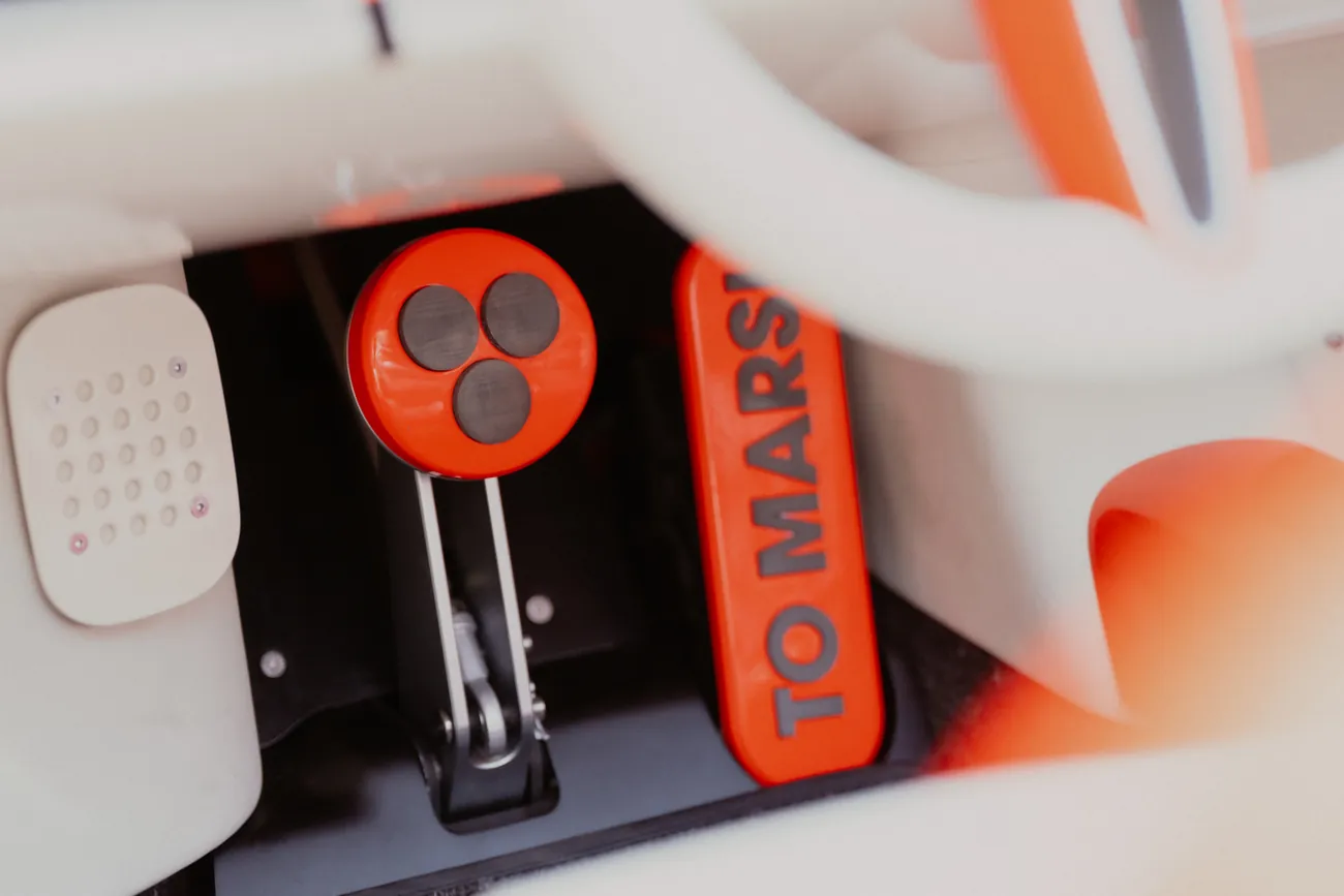 Footwell with a round brake pedal and an orange accelerator reading TO MARS!