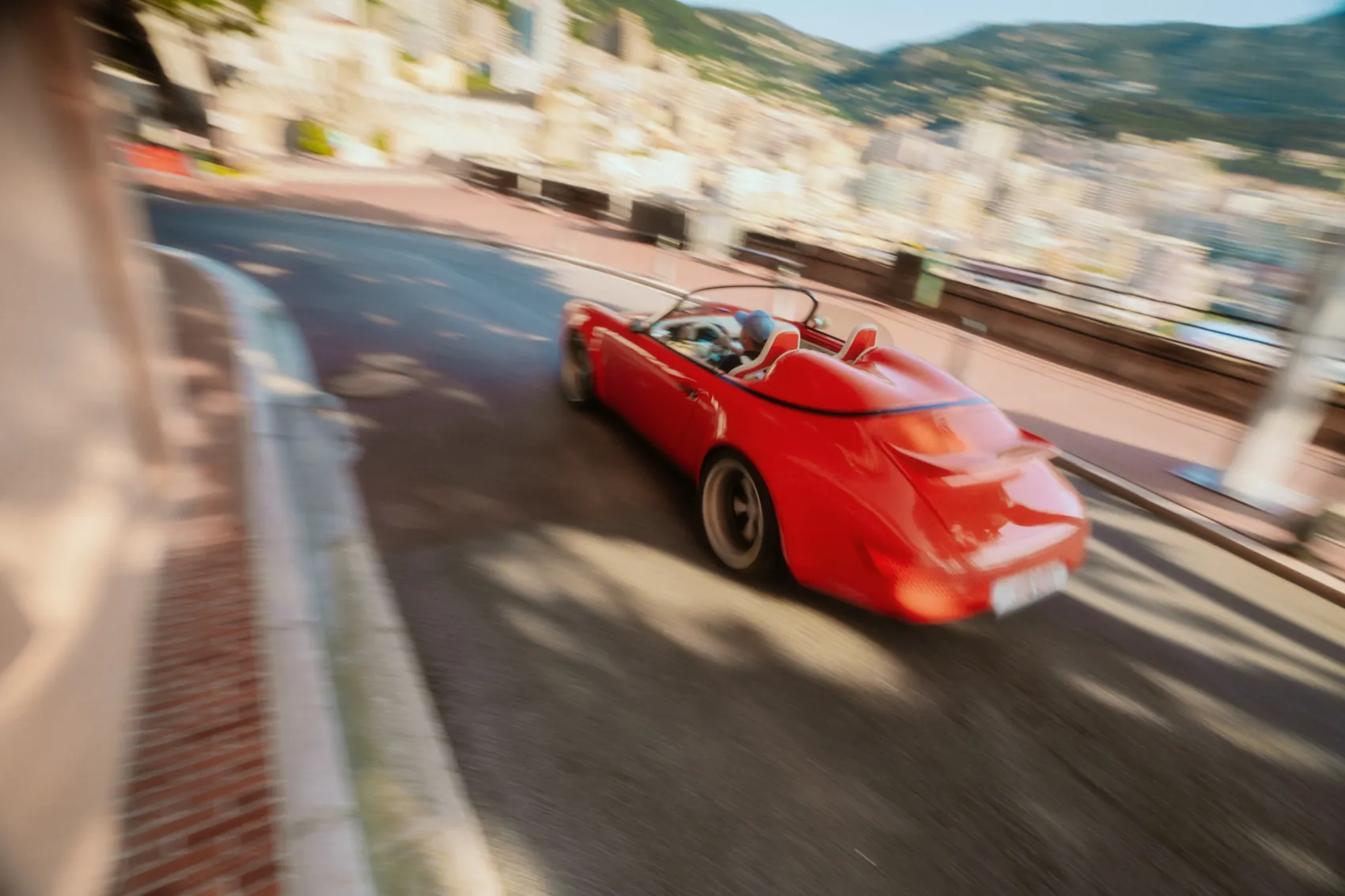 The Funkster taking a hairpin, city and sea behind